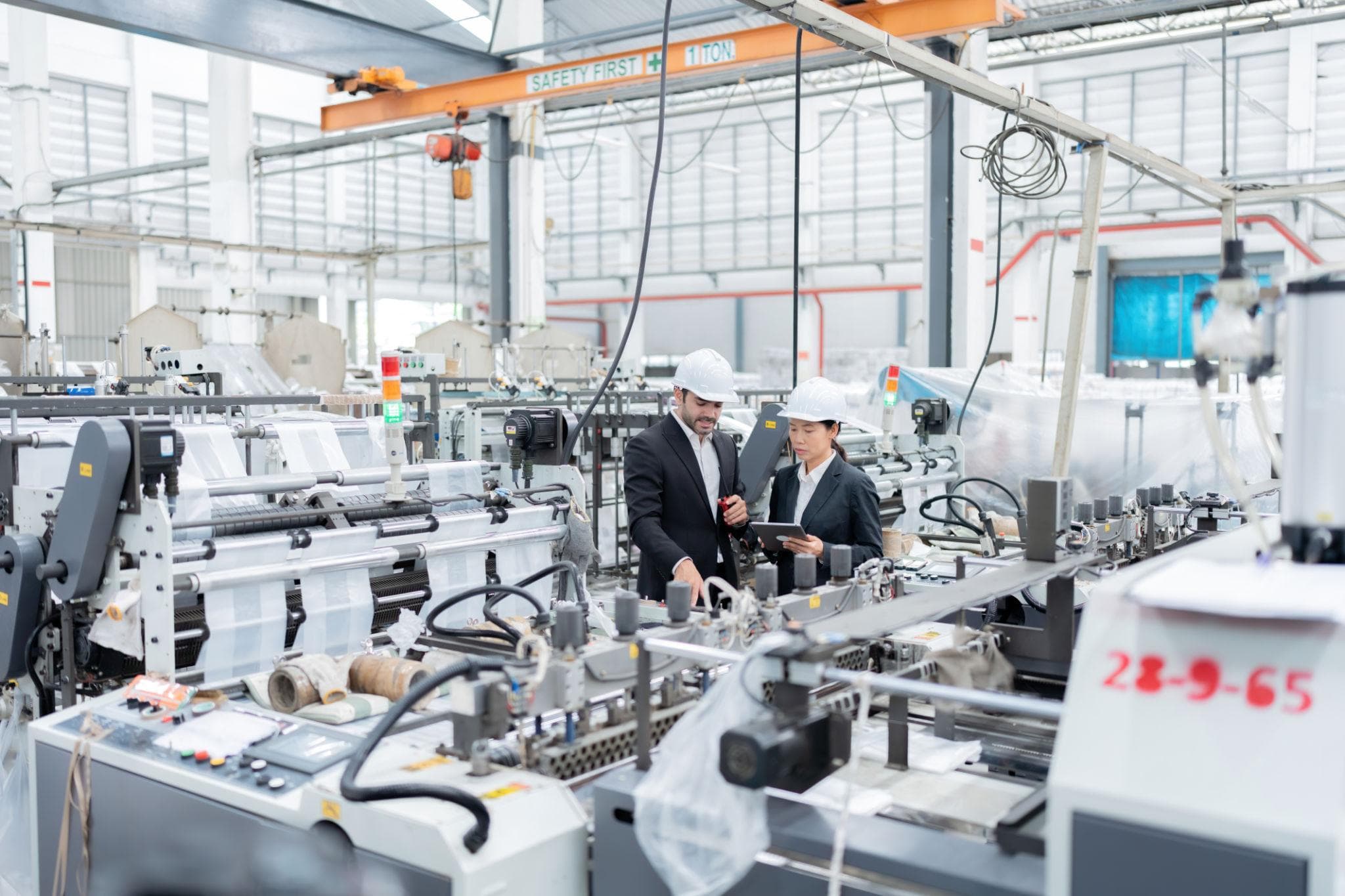 Engineers reviewing equipment on a manufacturing production line.