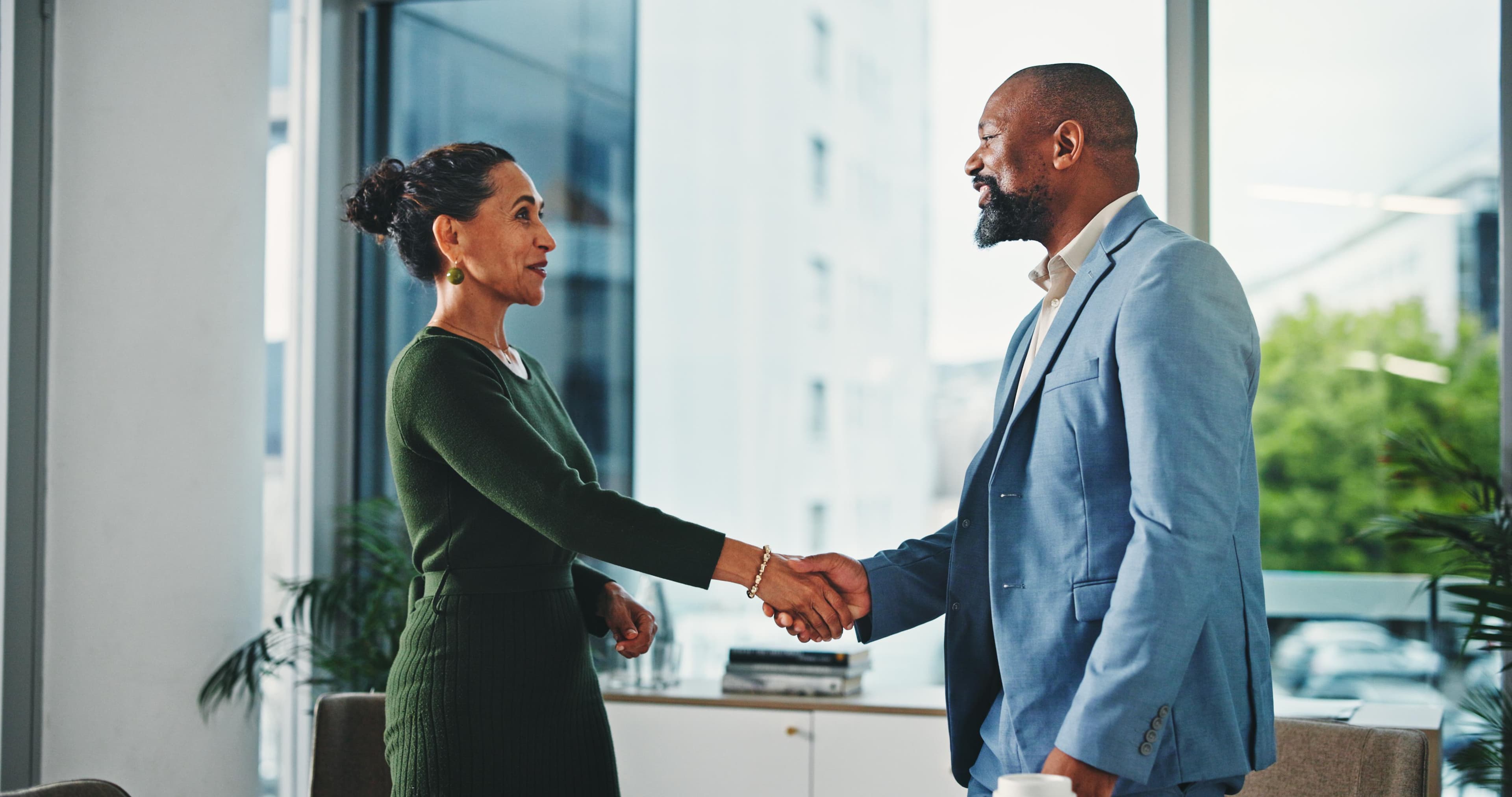Business leaders shaking hands after a successful long-term placement.